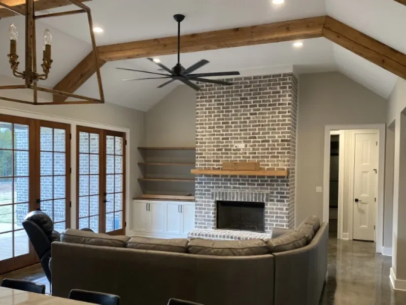 Living room interior built with brick fireplace and wood beams.